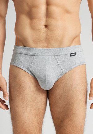 Graue Baumwollslips mit einer glatten Textur, ausgestattet mit einem breiten Bündchen und einem Front-Pouch-Design. Einfaches schwarzes Etikett am Bündchen.