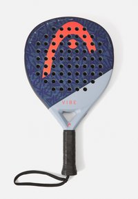 Padel rakete ar teksturētu zilu dizainu un sarkaniem akcentiem. Aprīkota ar melnu gumijas rokturi un plaukstas siksniņu, uz galvas ir redzami apaļi caurumi.