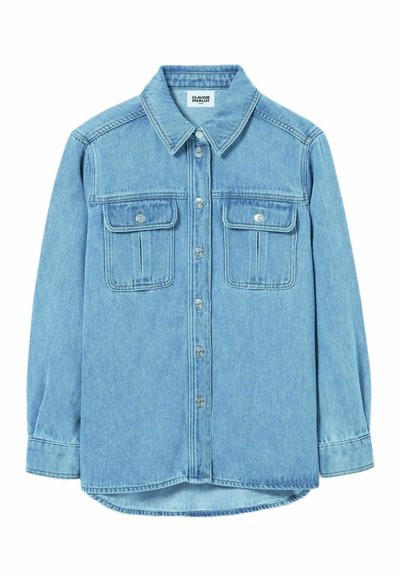 Camicia in denim azzurro chiaro con colletto a punta, pattina con bottoni e due tasche sul petto con alette. Maniche lunghe e orlo curvo.