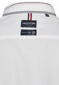 Witte overhemd met een gestructureerde kraag, een gemengd stoffen label met branding en contrasterende rode en marineblauwe strepen op de kraag.