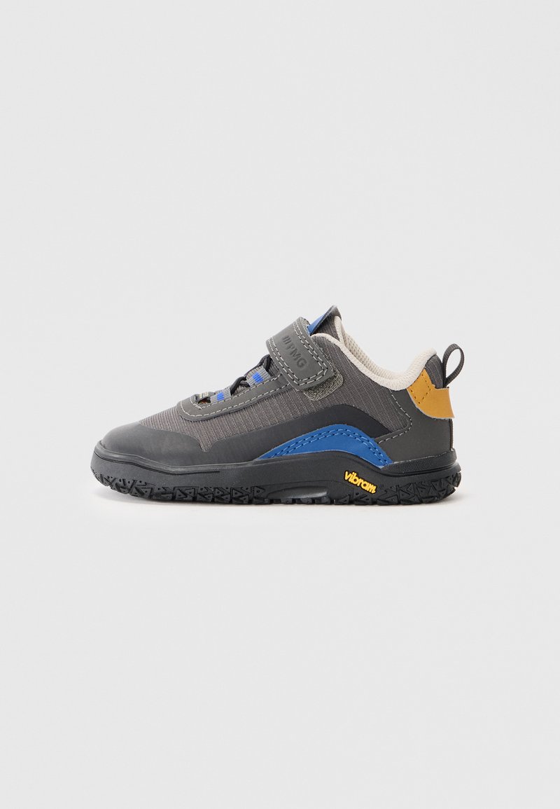 Dziecięcy but z szarym tekstylnym wierzchem, niebieskimi akcentami, rzepem, wyściełanym kołnierzem i czarną gumową podeszwą z oznaczeniem Vibram.