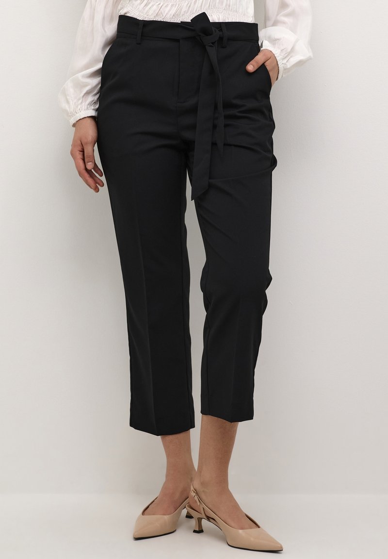 Svarta skräddarsydda byxor med knytbälte, kapad längd och en slät textur. Matchade med beige klackar med spetsig tå och unik klackdesign.