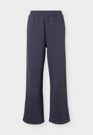 Σκούρο μπλε φαρδιά φόρμα με ελαστική μέση και πλαϊνές τσέπες σε απλό φόντο.