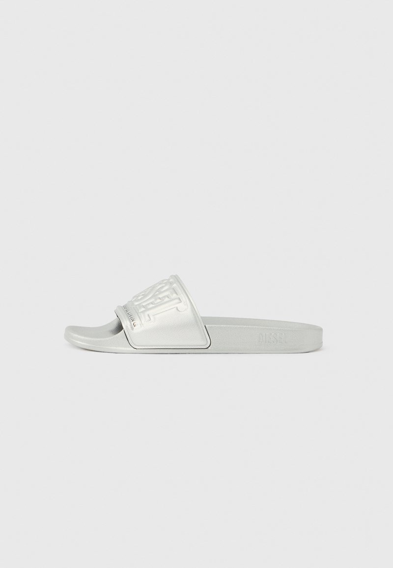 Siva papuča na klizanje s teksturiranim, uzdignutim logotipom na naramenici. Izrađena od izdržljivog materijala, s jednostavnom, glatkom tabanicom i minimalističkim dizajnom.