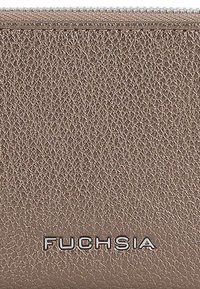 Portefeuille zippé fuchsia, fabriqué en cuir taupe texturé, avec des finitions en métal argenté et le nom de la marque embossé en bas.