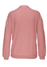 Top de manga larga rosa con textura acanalada, de corte relajado, que presenta un cuello y puños elásticos. La textura es suave, lo que realza la profundidad visual y el diseño.