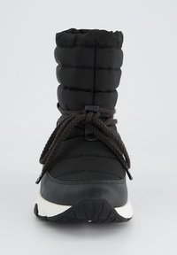 Botte en style doudoune noire avec une pointe arrondie, une tige texturée, un système de laçage et une épaisse semelle blanche. Présente un poignet froncé en haut.