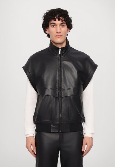 Black leather sleeveless jacket with a high collar, front zip, and two large front pockets. Smooth texture, fitted design, and ribbed hem.