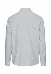 Jasnoszara koszula na długi rękaw z delikatnymi pionowymi paskami, klasycznym kołnierzem i zapinanymi na guziki mankietami, widziana od tyłu.