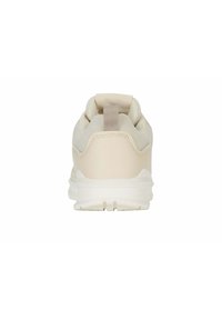 Zapatilla deportiva beige con parte superior de malla texturizada, un collar acolchado y una entresuela blanca. La parte trasera cuenta con una lengüeta de tela para facilitar su colocación.