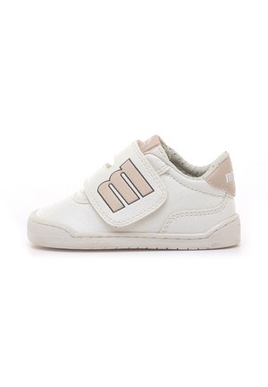 Zapatilla blanca para niño pequeño con detalles beige y una gran "m" en la tira de velcro para un fácil ajuste sobre suela de goma plana.