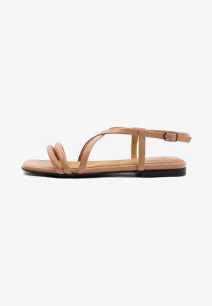 Tan flat sandals with three twisted straps and a buckle ankle strap. Smooth synthetic material and a flat black sole.