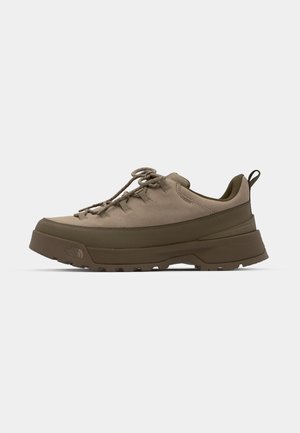 Light brown outdoor shoes featuring a textured fabric upper, rubber sole, lace-up design, and a heel loop for easy wear.