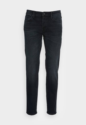 Dunkelblaue Denim-Jeans im Slim-Fit-Schnitt, mit fünf Taschen, einem Reißverschluss und einem klassischen Knopfverschluss. Glatte Textur und minimale Verblassung.