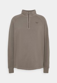 Sudadera de polar en marrón apagado con cremallera de un cuarto de longitud, mangas raglán y un sutil estampado del logo en el pecho. Textura suave.