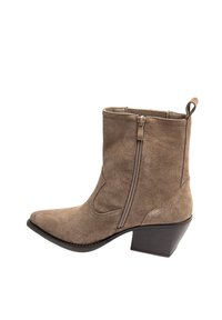 Bottines en suède beige à bout pointu, avec fermeture éclair sur le côté et un petit talon carré. Décorations de couture sur la tige.