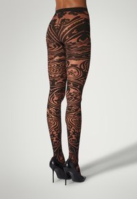 Sorte leggings med mønstrede indviklede svungne designs i en kontrasterende tone, med en glat tekstur og høj talje, parret med højhælede sko.