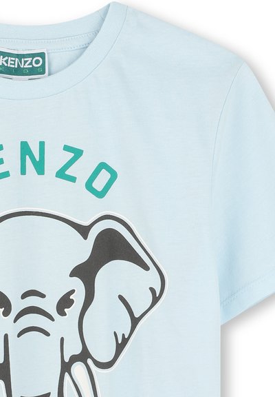 T-shirt en coton bleu clair avec un grand graphique d'éléphant noir entouré d'un contour blanc et le texte "KENZO" en vert au-dessus du design.