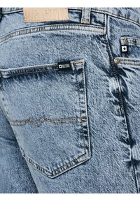 Hele sinise teksade lähivaade, mis näitab tagataskut, õmbluste detaile ja taskul ning vöökohal asuvaid "BIG STAR" kaubamärgiga silte.