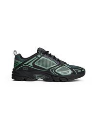 Baskets de sport noires et vertes avec tissu en maille, semelle épaisse, bout arrondi et accents contrastants. Comprend des lacets et des détails de marque.
