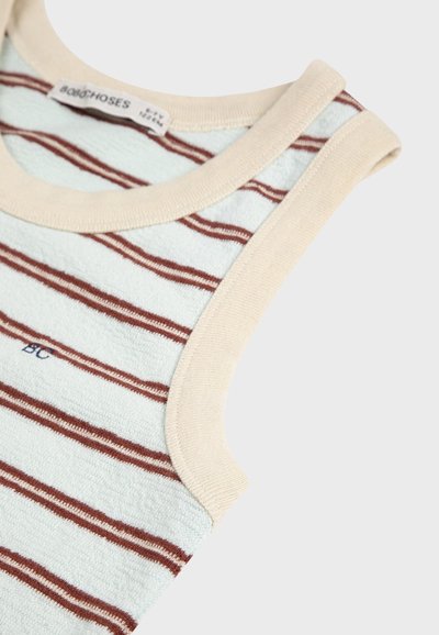 Gros plan sur un haut sans manches en tissu éponge bleu clair avec de fines rayures horizontales marron et un bord beige autour de l'encolure et de l'emmanchure.