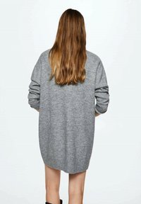 Przewiewny szary sweter o oversize'owym kroju, wykonany z miękkiego dzianinowego materiału, z długimi rękawami i ściągaczem u dołu, w luźnym kroju z opadającym ramieniem.