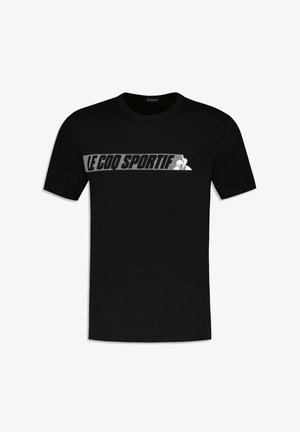 Camiseta de algodón negra con un logo horizontal en blanco y gris de "LE COQ SPORTIF" en el pecho. Diseño de mangas cortas y cuello redondo.