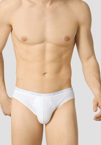 Slip in cotone bianco con logo Sloggi sull'elastico, caratterizzati da una vestibilità aderente e una texture liscia.