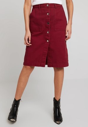Jupe en denim bourgogne avec une coupe mi-longue, fermeture à boutons sur le devant, deux poches avant et une fente pour plus de liberté de mouvement.