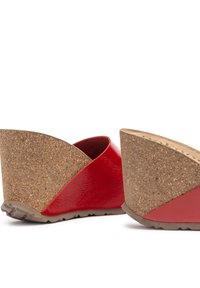 Red patent leather wedged sandals with a cork heel, featuring a curved design and textured surface. Sole has a rubber tread for grip.