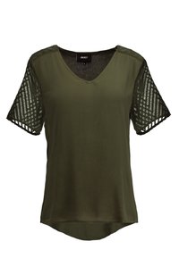 Oliven grøn bluse med korte ærmer og V-hals, der har blonderdetaljer på ærmerne og en buet nederste række. Silkeagtig tekstur.
