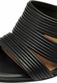 Sandalias negras con parte superior de cuero acanalado, diseño de punta abierta y una plantilla de textura suave con una base marrón claro en contraste.