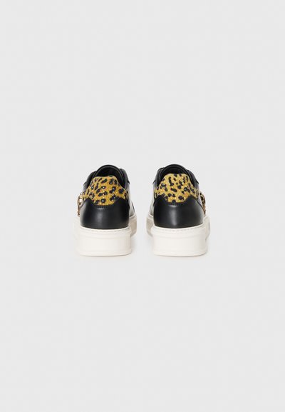 Sneakers in pelle nera con un pannello in stampa leopardata gialla e nera. Soletta bianca, con un accento in hardware dorato sul lato.