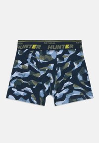 Boxer per ragazzi con motivo a camuffamento astratto blu, nero e verde e vita nera con testo "NATURAL HUNTER" in giallo e grigio.