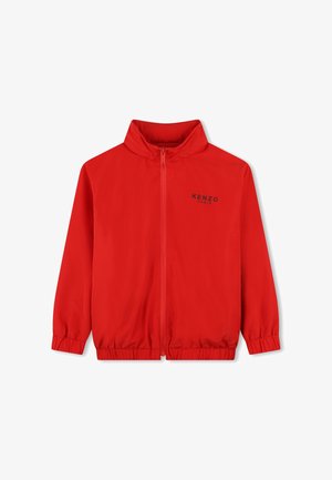 Veste zippée rouge en matériau léger. Comprend un col montant, des poignets élastiques et un logo imprimé sur la poitrine gauche.
