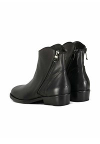 Un paio di stivali in pelle nera alla caviglia con cerniere laterali e tacchi bassi a blocco, mostrati da una vista posteriore a tre quarti.