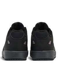 Czarne buty sportowe z gładką cholewką, miękką wyściółką, gumową podeszwą i wyściełanym kołnierzem z dwoma bocznymi otworami wentylacyjnymi.