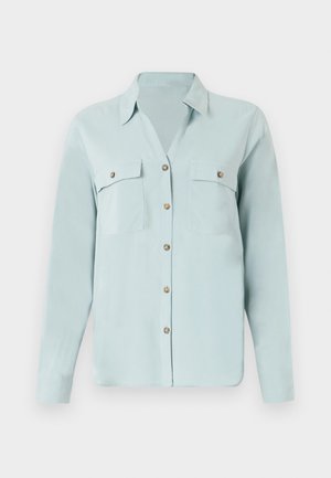 Hele sinine pika varrukaga särk, millel on krae, kaks rinna taskut, kuldse tooni nööbid ja sile, tekstuuriga kangas.