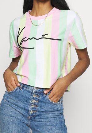 Gestreiftes Cropped-T-Shirt in Pastellfarben (Pink, Grün, Gelb) mit einem schwarzen Signaturgrafik. Kombiniert mit hoch taillierten Jeans.