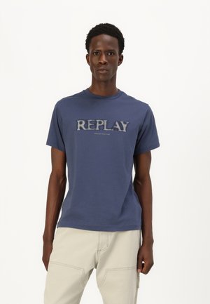 Camiseta de algodón azul marino con una textura suave, que presenta un audaz logo bordado "REPLAY" en un color contrastante a lo largo del pecho.