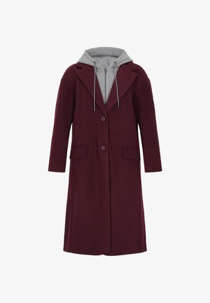 Burgundowy długi płaszcz z pojedynczym guzikiem, z szarym dresowym swetrem pod spodem. Materiał ma gładką fakturę i dwa boczne kieszenie.