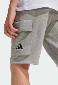 Gray cotton shorts with a side pocket, featuring a black Adidas logo. Soft texture with a casual fit.