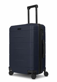 Maleta rígida de color azul marino con superficie texturizada, un asa telescópica y cuatro ruedas negras. Cuenta con cierre de cremallera y un pequeño candado.