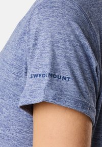 T-shirt a maniche corte blu mélange con il logo visibile "SWEDMOUNT" sulla manica. Realizzato in tessuto morbido, dalla texture liscia.
