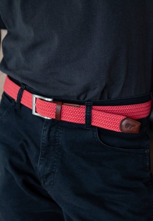 Rode gevlochten riem gemaakt van elastisch materiaal, met een zilveren metalen gesp en bruin leren accenten. Draagt goed bij donkere broeken.
