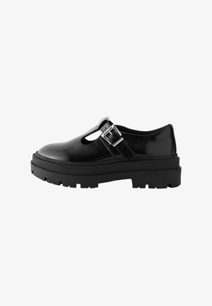 Zwarte patenten leren schoenen met een ronde neus, een uitgesneden opening en een zijgesp, met een dikke, robuuste zwarte zool.