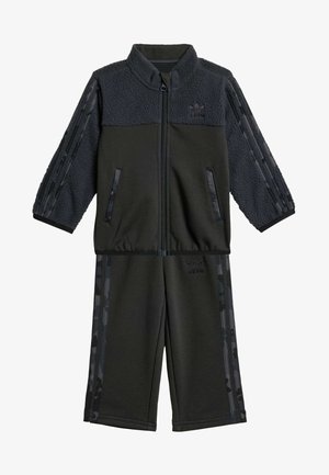 Tuta nera realizzata in pile e poliestere. Caratterizzata da una giacca zip con maniche decorate e pantaloni con vita elastica. Marchiata con logo.