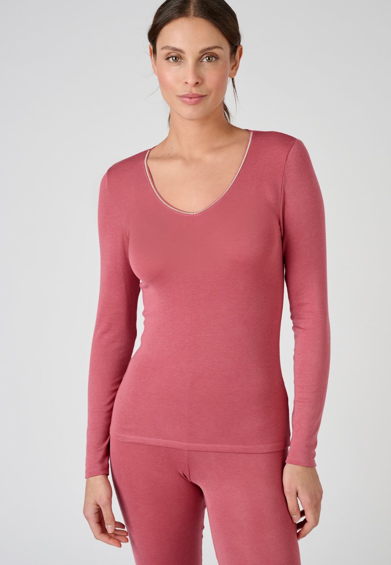 Maglietta a maniche lunghe, con scollo a V, in morbido tessuto rosa, caratterizzata da una texture liscia e da una sottile cucitura a contrasto lungo il colletto e l'orlo.