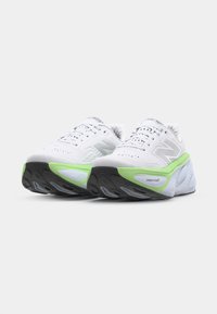 White running shoes with a textured mesh upper, green midsole accents, and a black rubber outsole. Features a prominent "N" logo.