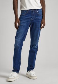 Mörkblå denimjeans med rak bendesign, som har en klassisk femfickedesign och subtila whiskeringdetaljer.